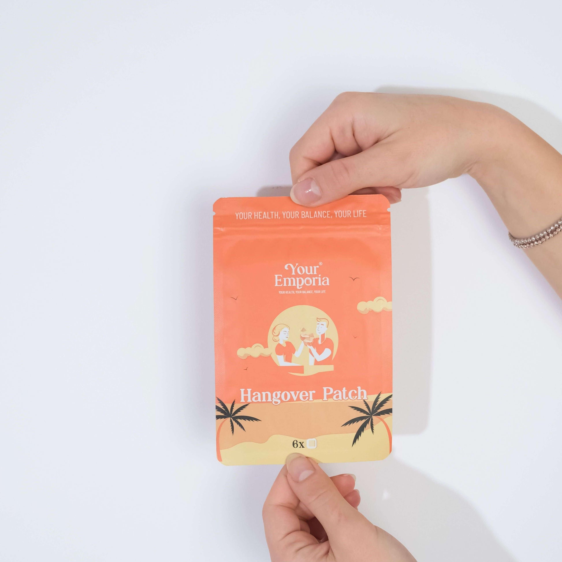 Person holding 'Your Emporia' Hangover Patch packaging with tropical design, promoting health and balance.